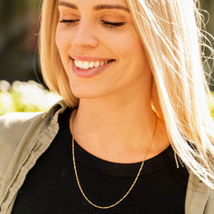 Gold plated 1.2mm Flat Cobra Chain Necklace worn by a woman as her necklace
